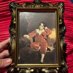 Vintage -The Red Boy- in a plastic black/ gold trim- 9 1/2” by 7” preloved